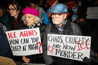 People held signs criticizing ICE